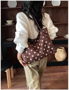Vue détaillée d'un sac cabas rétro à pois marron porté par un modèle dans un décor vintage.