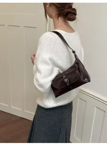 Chic brown patent leather underarm shoulder bag, stylish detail shot for modern women.