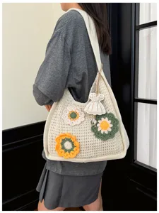 Detailed view of the knit tote bag with floral accents and a mini dress pendant for daily use.