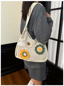 Detailed view of the hollow-out crochet knitted floral tote bag single-shoulder strap design.