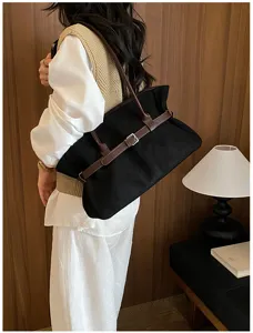 Detailed view of large capacity black suede tote shoulder bag with brown leather strap detail.