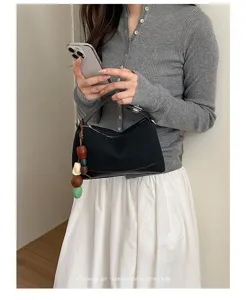 Koreanische minimalistische schwarze Schultertasche mit Holzperlenanhänger für Alltag.