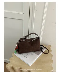 Braune Wildleder Handtasche mit verstellbarem Schultergurt und Anhänger für den Alltag.
