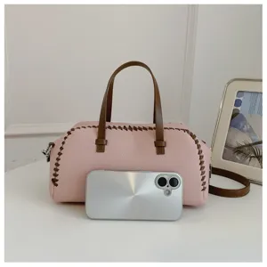 Stijlvolle roze en bruine contrasterende Boston tas met handvatten en schouderband voor vrouwen.