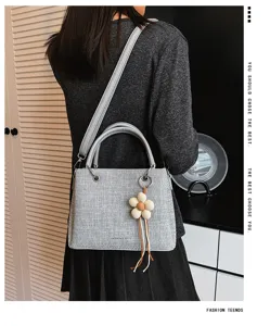Elegante bolso de hombro gris de tela con bonito colgante de flor para uso diario.