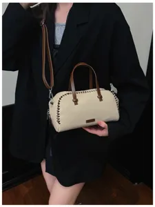 Gedetailleerd overzicht van de stijlvolle beige en bruine Boston tas met mooie kruissteken.