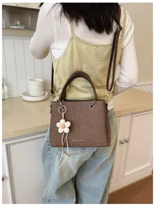 Bolso de hombro texturizado marrón para mujer, elegante bolso cruzado con dije de flor.