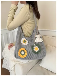 Detailed shot of a large crochet knit tote bag for women with floral appliques and a dress charm.