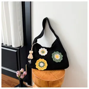 Detailed view of the black crochet knit shoulder bag with handmade colorful floral appliques.