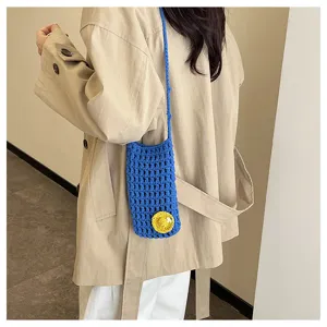 Handgefertigte blaue Häkel-Handytasche Detail mit niedlicher gelber Blumen-Applikation Riemen.