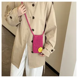 Detailansicht der handgearbeiteten Häkel-Handytasche am Modell mit feiner Maschenstruktur.