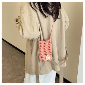 Detailaufnahme einer rosa gehäkelten Handytasche im Umhängeformat mit kleinem Blumenmuster.