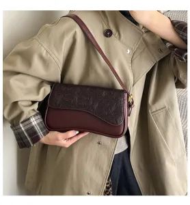 Detailed view of a chic French style burgundy leather shoulder bag with embossed flap design.