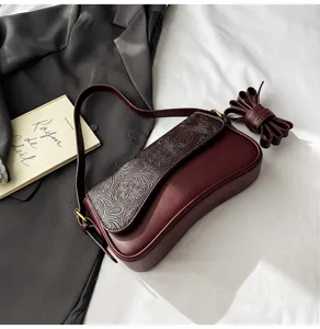 Chic burgundy leather shoulder bag with embossed flap and trendy French retro style.