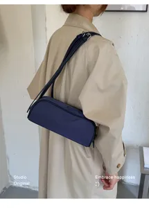 Minimalist solid color underarm shoulder bag for women, stylish commuter baguette handbag.
