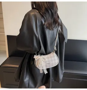 Detailopname van Koreaanse geruite okseltas met kanten parel strik hangende accessoire.