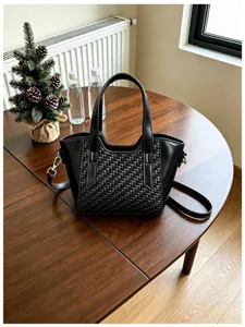 Vue détaillée du sac à main pour femme noir texturé tressé avec poignées et bandoulière.