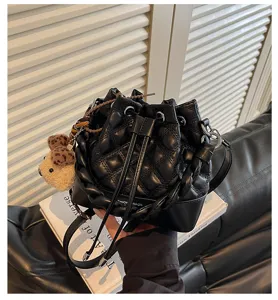 Black quilted bucket bag with braided handle and cute bear pendant, stylish women shoulder bag.