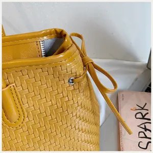 Primer plano de los detalles del bolso de cuero tejido amarillo con textura.