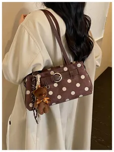 Vue détaillée du sac porté épaule marron à pois avec boucle en métal et pendentif ours.