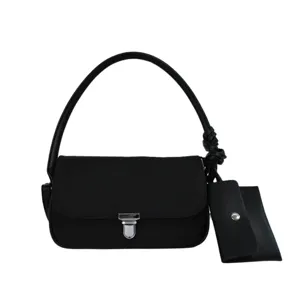 Stylish black underarm baguette bag for women, featuring a metal lock and chic shoulder strap.