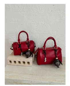 Détail de sac baril en cuir PU rouge, sac à main rétro minimaliste chic avec charmant pendentif.
