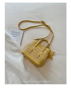Borsa a tracolla traforata gialla con ciondolo a stella, elegante borsa retro.