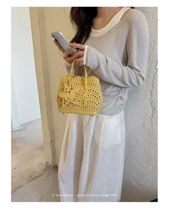 Elegante borsa a mano gialla traforata con ciondolo a stella, perfetta per look chic.