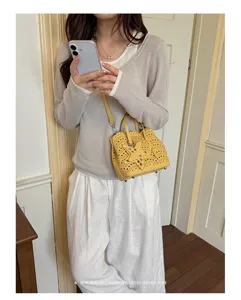 Dettaglio borsa a tracolla gialla, borsa elegante con design traforato e stella.