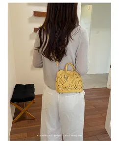 Borsa a tracolla gialla con motivo traforato al laser e ciondolo a stella, accessorio casual ed elegante.