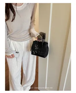Mini borsa a tracolla minimalista in pelle nera con dettagli traforati chic ed eleganti.