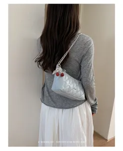 Stylish quilted underarm bag with chain strap and cherry charm, detailed back view.
