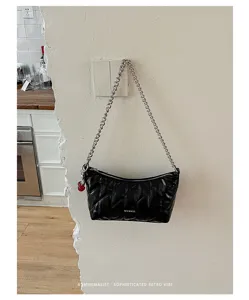 Black quilted shoulder bag with chain strap and chic design. Perfect minimalist baguette for women.