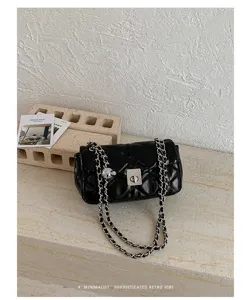 Zwarte gewatteerde schoudertas van leer met elegante ketting en chique draaisluiting.