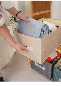 Dettaglio di una pratica scatola di stoccaggio pieghevole in lino con manico per armadio.
