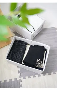 Detalle de la caja de almacenamiento de tela con ropa doblada ordenadamente en su interior.