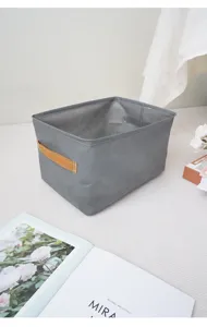 Grey fabric storage basket with handles for home wardrobe and closet organization.