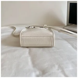 Mini sac bandoulière style moto blanc avec clous métalliques, sac tendance pour femmes.