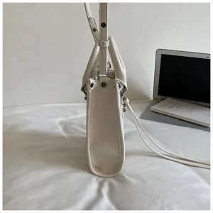 Sac bandouliere en cuir blanc style moto avec rivets vue laterale tendance mode ete
