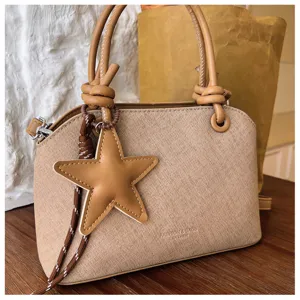 Nahaufnahme der koreanischen PU-Lederhandtasche mit Knotengriff und Sternanhänger.