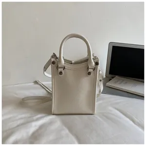 Sac bandoulière vertical mini blanc chic avec poignée et détails de rivets élégants.