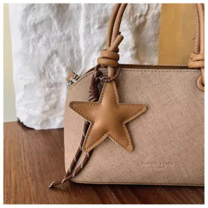 Detailansicht der stilvollen koreanischen Handtasche mit Sternanhänger und Knotengriff.