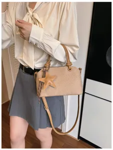 Nahaufnahme der trendigen Umhängetasche im koreanischen Stil mit Sternanhänger und Knoten.