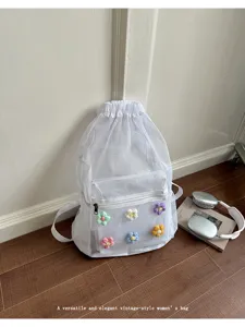 White mesh drawstring backpack with colorful crochet floral details, casual daily use detail.
