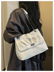 Vue détaillée du sac à épaule blanc élégant avec motif d'étoiles et chaîne métallique.