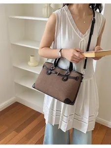 Classic canvas shoulder bag for women, stylish brown handbag with leather trim and metal clasp.