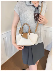 Detailaufnahme der lässigen Canvas-Umhängetasche mit braunem Lederbesatz und robustem Griff.
