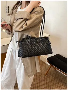 Detalle de bolso de hombro negro tejido con textura elegante y look diario con estilo.
