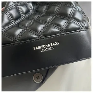Detailed view of black quilted leather bucket shoulder bag with elegant grid pattern.