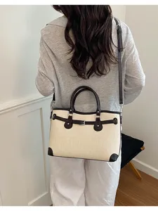 Minimalist canvas shoulder bag for women, stylish commuting tote bag with brown leather trim.